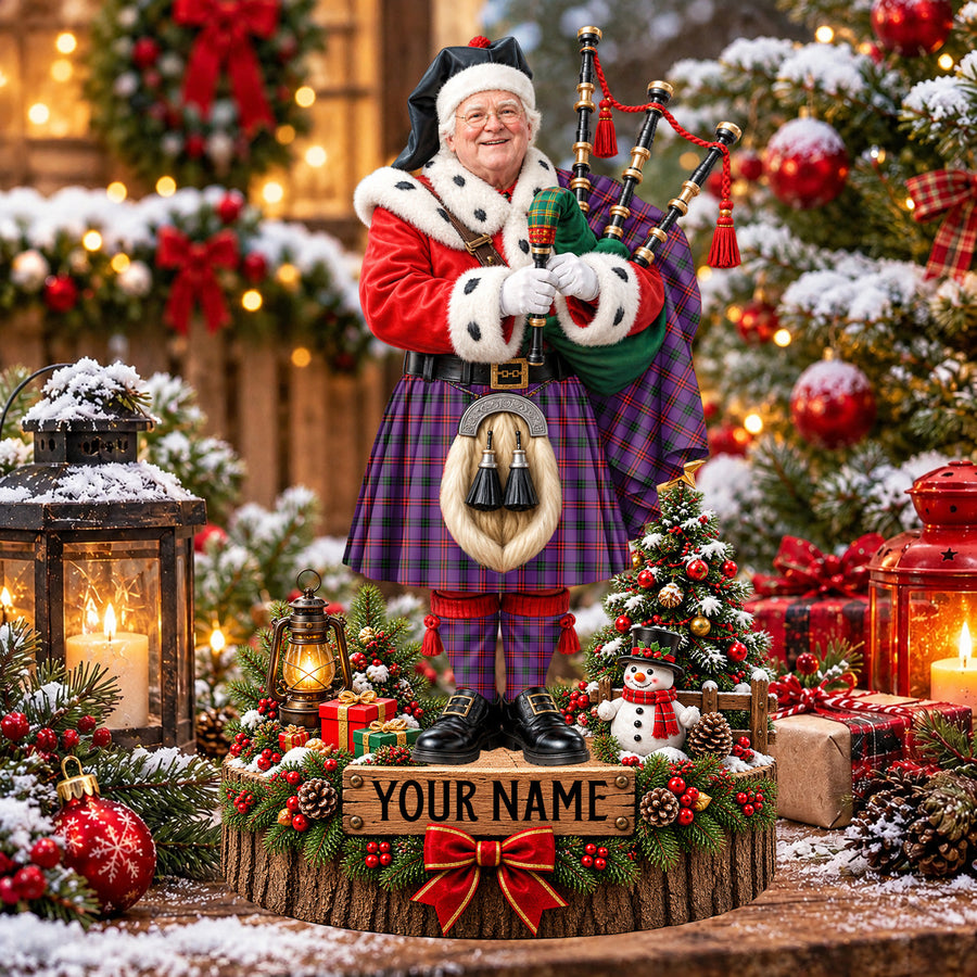 Personalized Christmas piper plaque in the Montgomery Modern tartan, standing on a snowy log base with a name plaque