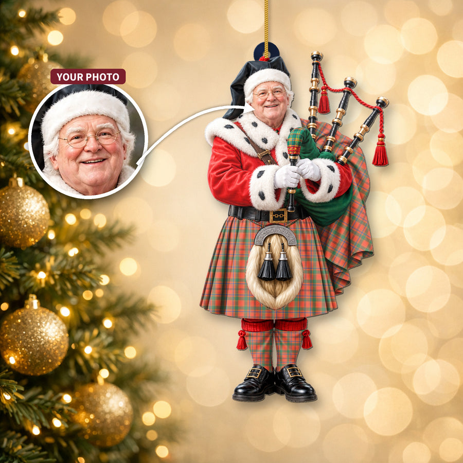 Christmas piper ornament in the Munro Ancient tartan hanging on a Christmas tree, with the customer photo used for the face
