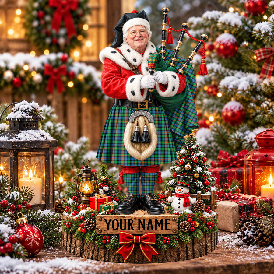 Personalized Christmas piper plaque in the Murray of Atholl Ancient tartan, standing on a snowy log base with a name plaque
