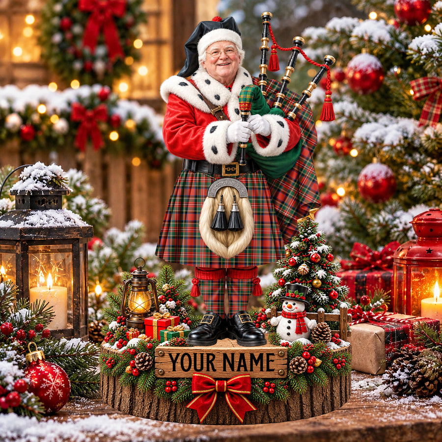Personalized Christmas piper plaque in the Stewart Royal Modern tartan, standing on a snowy log base with a name plaque