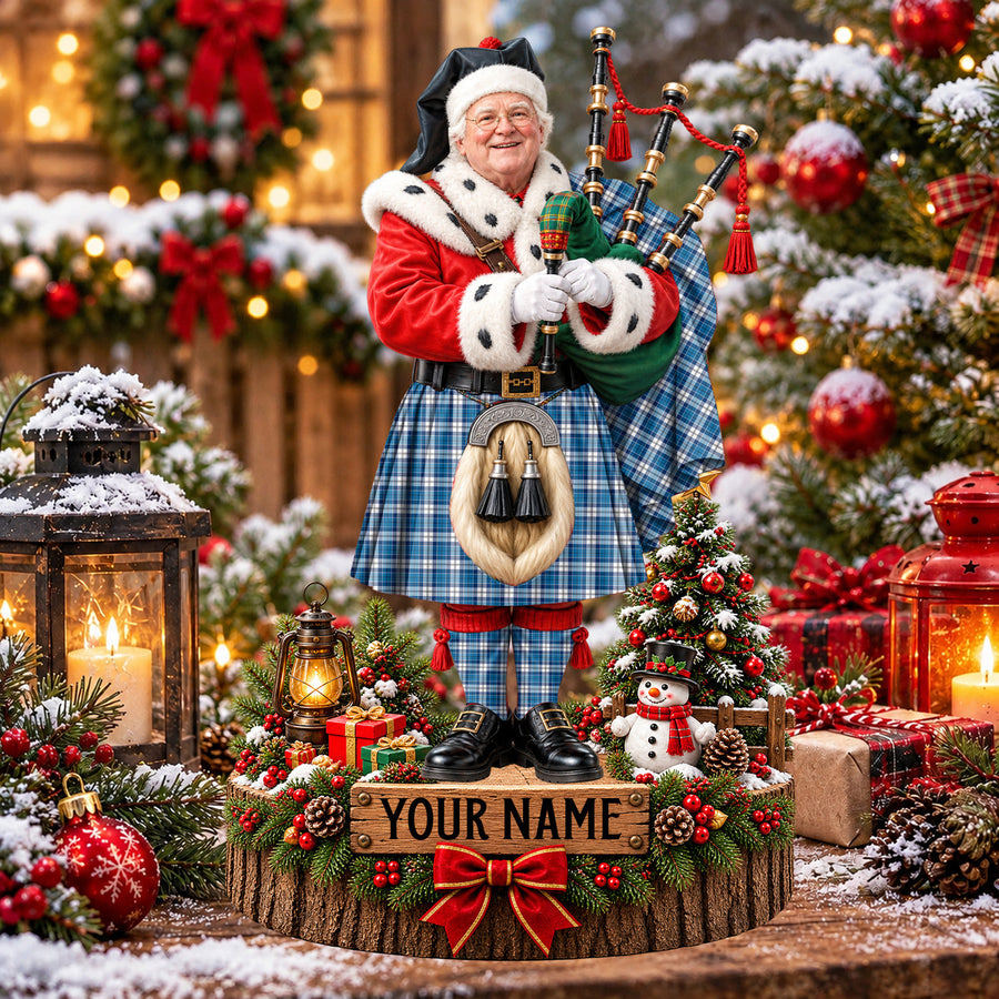 Personalized Christmas piper plaque in the Strathclyde District tartan, standing on a snowy log base with a name plaque