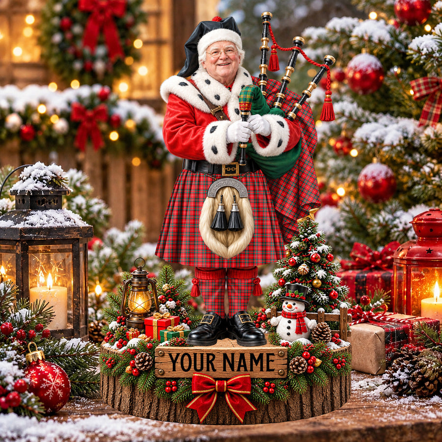 Personalized Christmas piper plaque in the Stuart of Bute tartan, standing on a snowy log base with a name plaque
