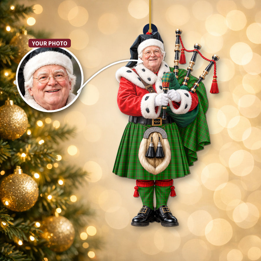 Christmas piper ornament in the Tribe of Mar tartan hanging on a Christmas tree, with the customer photo used for the face