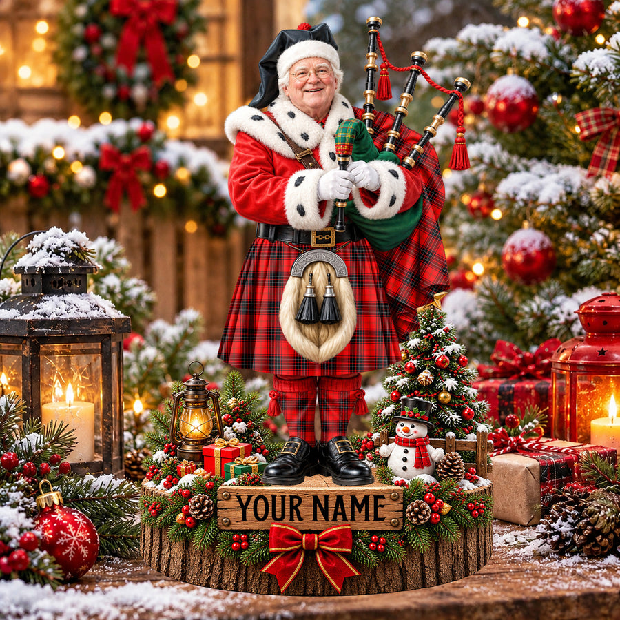 Personalized Christmas piper plaque in the Wemyss Modern tartan, standing on a snowy log base with a name plaque