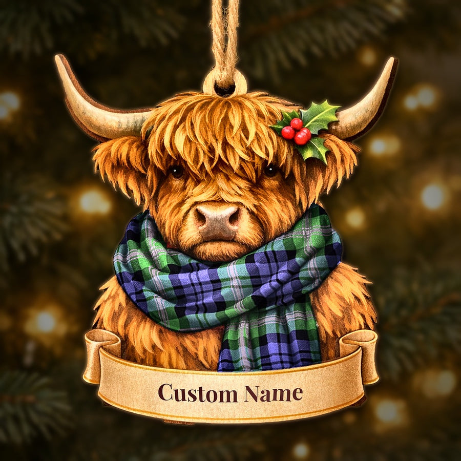 Wooden Highland cow Christmas ornament wearing a Baird Modern tartan scarf, with a ribbon banner for a custom name