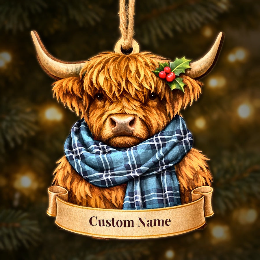 Wooden Highland cow Christmas ornament wearing a Earl of St Andrews tartan scarf, with a ribbon banner for a custom name