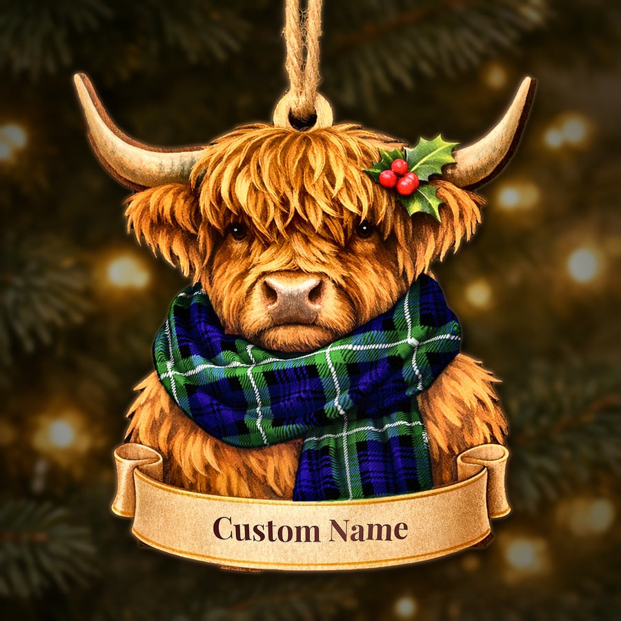 Wooden Highland cow Christmas ornament wearing a Lamont Modern tartan scarf, with a ribbon banner for a custom name