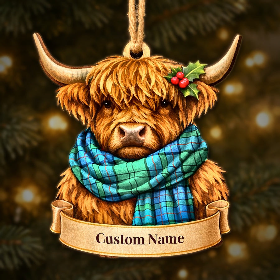 Wooden Highland cow Christmas ornament wearing a Lockhart tartan scarf, with a ribbon banner for a custom name