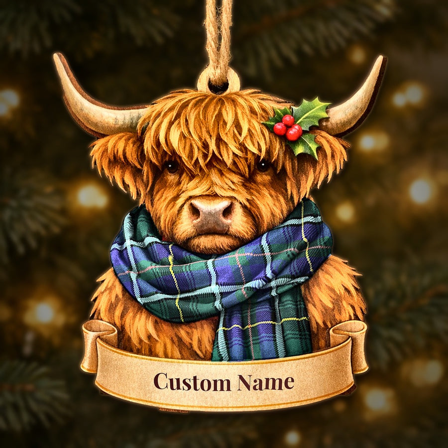 Wooden Highland cow Christmas ornament wearing a MacInnes Modern tartan scarf, with a ribbon banner for a custom name