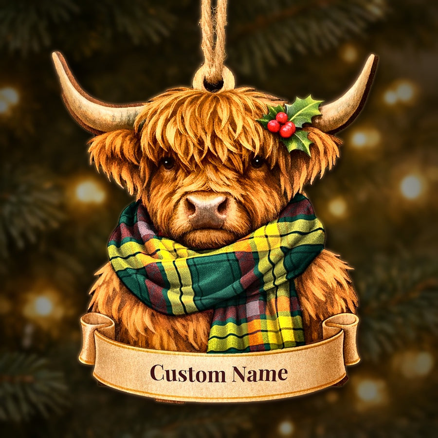 Wooden Highland cow Christmas ornament wearing a MacMillan Old Modern tartan scarf, with a ribbon banner for a custom name