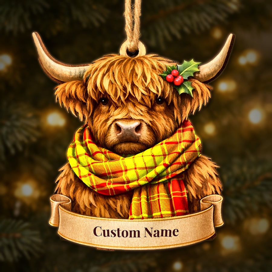 Wooden Highland cow Christmas ornament wearing a MacMillan tartan scarf, with a ribbon banner for a custom name