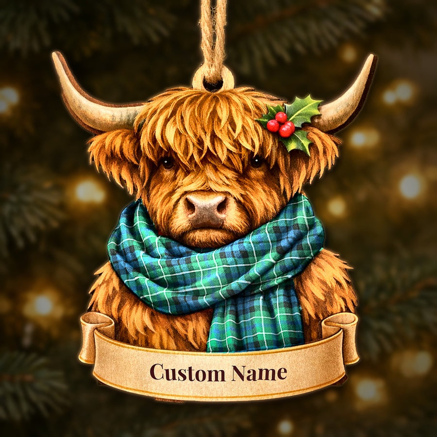 Wooden Highland cow Christmas ornament wearing a MacNeill of Colonsay Ancient tartan scarf, with a ribbon banner for a custom name