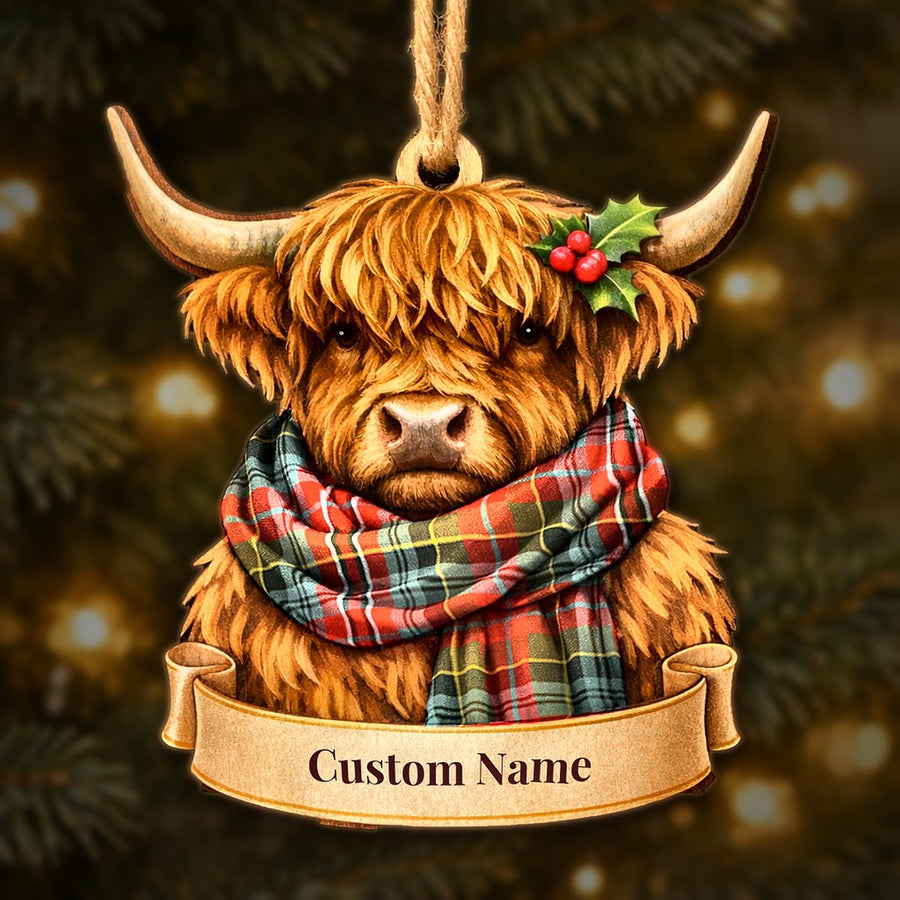 Wooden Highland cow Christmas ornament wearing a MacPherson Weathered tartan scarf, with a ribbon banner for a custom name
