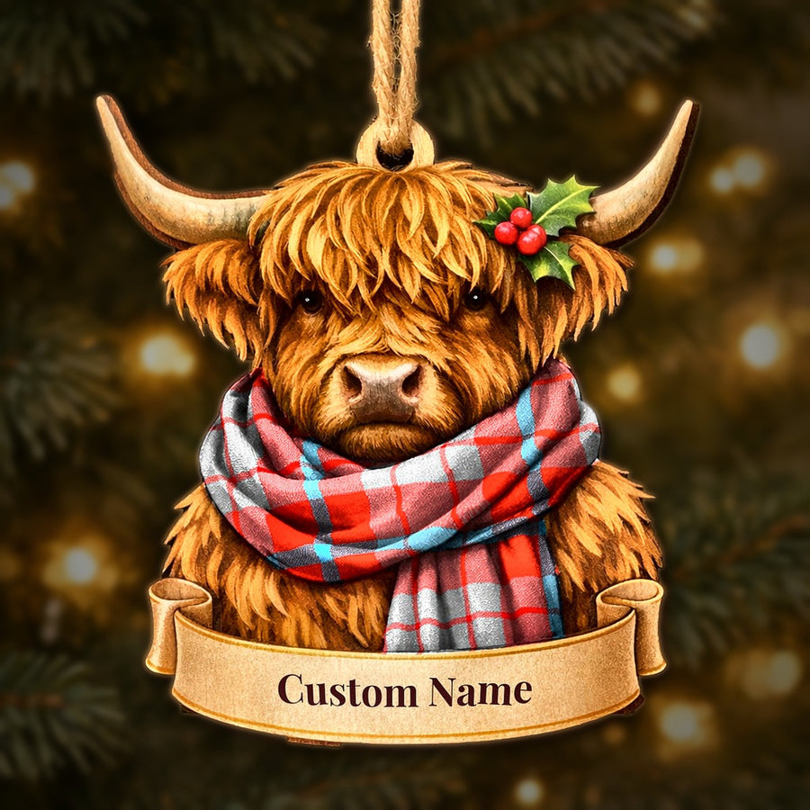 Wooden Highland cow Christmas ornament wearing a Moubray tartan scarf, with a ribbon banner for a custom name