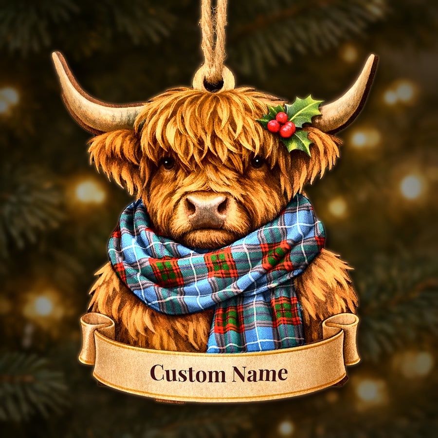 Wooden Highland cow Christmas ornament wearing a Newton (Edingburg) tartan scarf, with a ribbon banner for a custom name