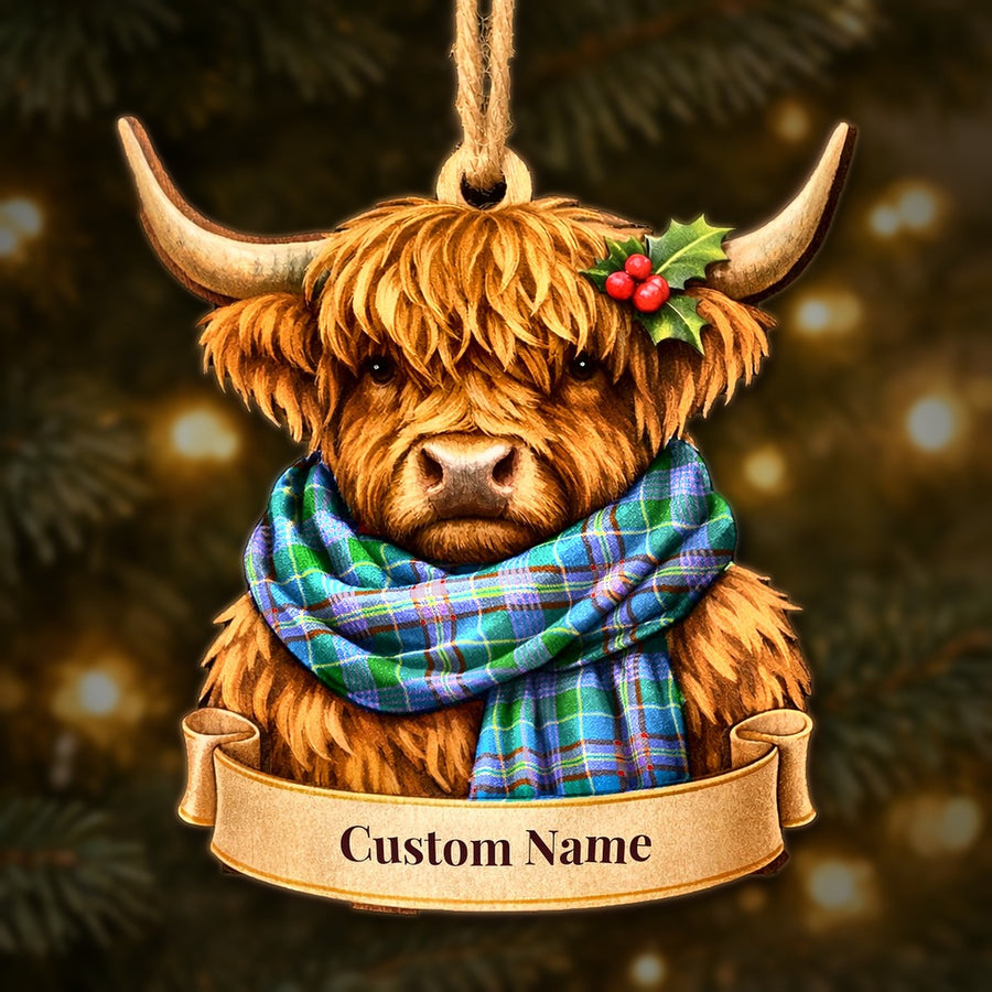 Wooden Highland cow Christmas ornament wearing a Pitcairn Hunting tartan scarf, with a ribbon banner for a custom name
