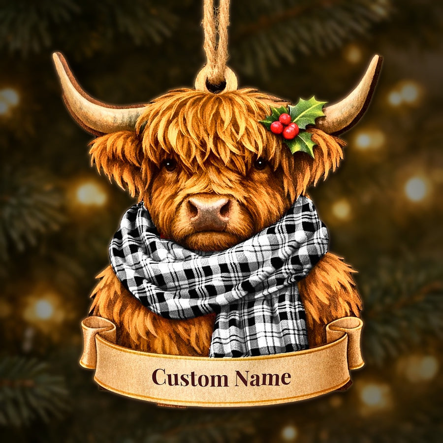 Wooden Highland cow Christmas ornament wearing a Scott Black & White Modern tartan scarf, with a ribbon banner for a custom name