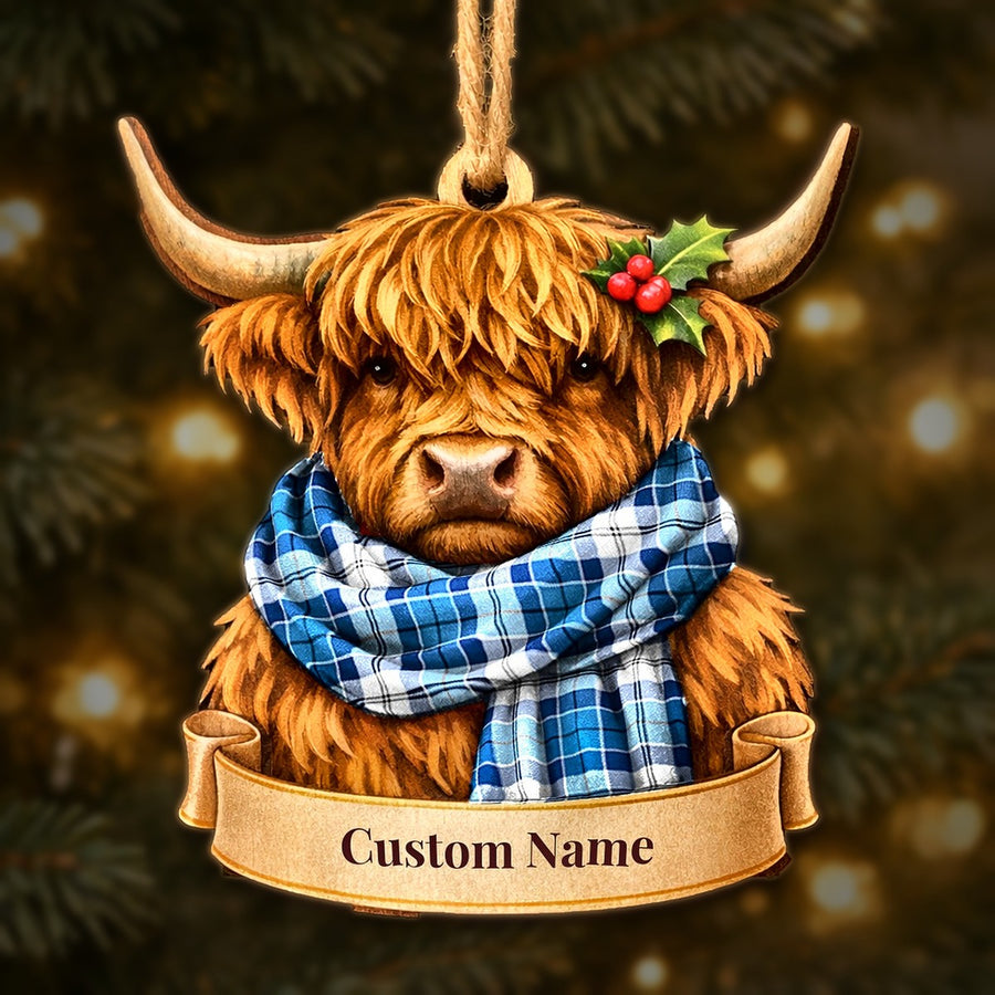 Wooden Highland cow Christmas ornament wearing a Strathclyde District tartan scarf, with a ribbon banner for a custom name